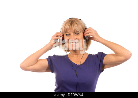 Ältere Frau 50-60Jahre Musikhören mit Stereo-Kopfhörer auf weißem Hintergrund. Stockfoto