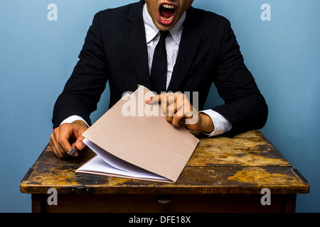 Müde Geschäftsmann sucht über wichtige Dokumente Stockfoto