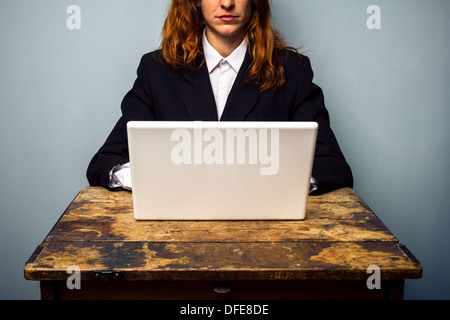 Junge Geschäftsfrau ist an alten Schreibtisch saß und auf ihrem Laptop arbeiten Stockfoto