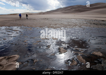 Das Wasser des Medano Creek fließt kurz über eine sandige waschen vor dem verschwinden, Great Sand Dunes National Park, Colorado. Stockfoto