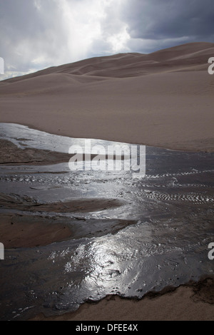 Das Wasser des Medano Creek fließt kurz über eine sandige waschen vor dem verschwinden, Great Sand Dunes National Park, Colorado. Stockfoto