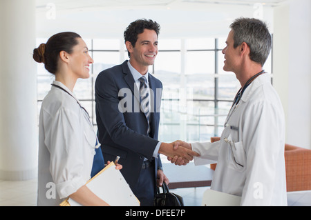 Arzt und Geschäftsmann Handshake im Krankenhaus lobby Stockfoto
