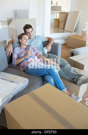 Paar erholsame mit Kaffee auf Sofa im neuen Haus Stockfoto