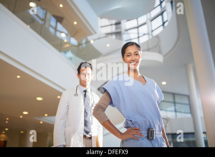 Porträt des Lächelns, Arzt und Krankenschwester im Krankenhaus atrium Stockfoto