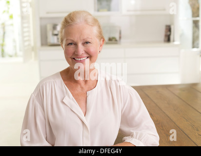 Ältere Frau lächelnd in Küche Stockfoto