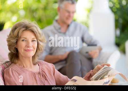 Ältere Frau liest Zeitung auf Terrasse Stockfoto