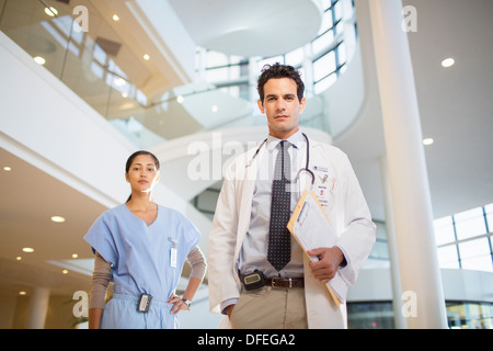 Porträt von zuversichtlich, Arzt und Krankenschwester im Krankenhaus atrium Stockfoto