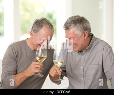 Senioren Herren Lachen und trinken Weißwein Stockfoto