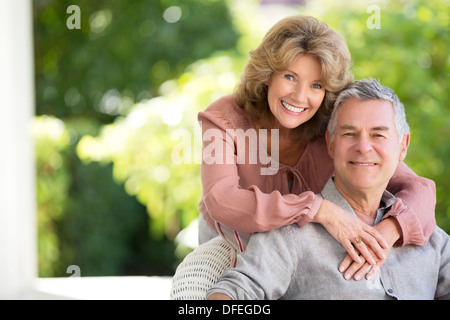 Älteres paar umarmt auf Terrasse Stockfoto