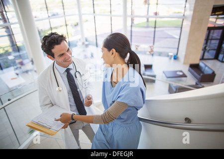 Arzt und Krankenschwester reden auf Treppe im Krankenhaus Stockfoto