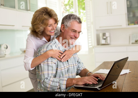 Älteres Paar mit Laptop in der Küche Stockfoto