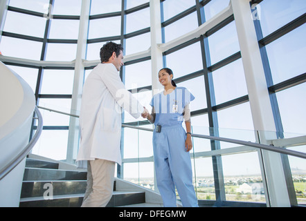 Arzt und Krankenschwester Handshaking auf Krankenhaus-Treppe Stockfoto