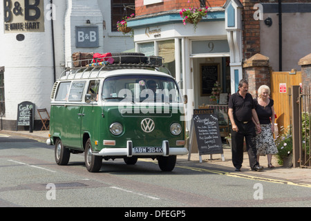 Classic Volkswagen camper Van, grün, mit einem Dachgepäckträger mit einem altmodischen Koffer / trunk auf es geschnallt. Stockfoto