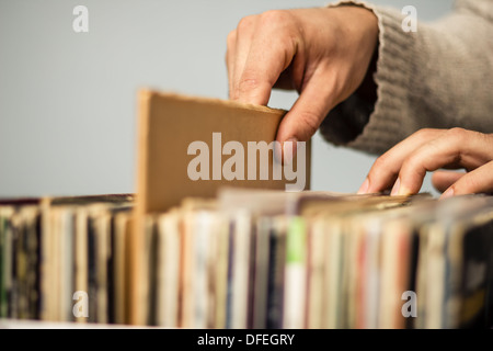 Hautnah an den Händen eines jungen Mannes, als er Schallplatten Surfen ist Stockfoto