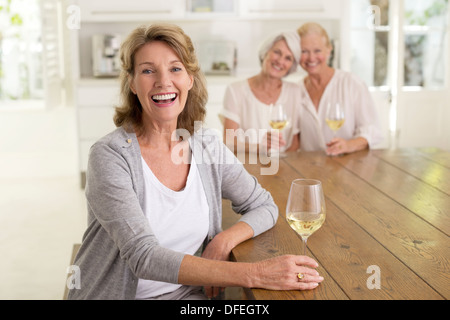 Porträt des Lächelns senior Frauen trinken Weißwein Stockfoto