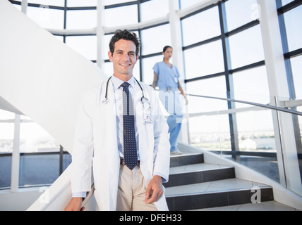 Porträt von lächelnden Arzt auf Treppe im Krankenhaus Stockfoto