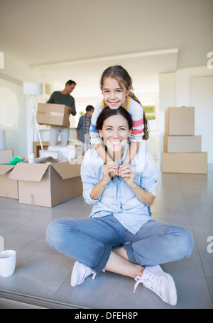 Porträt des Lächelns, Mutter und Tochter unter Kartons Stockfoto