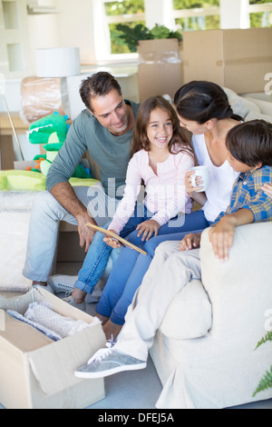 Familie entspannend auf Sofa im neuen Haus Stockfoto