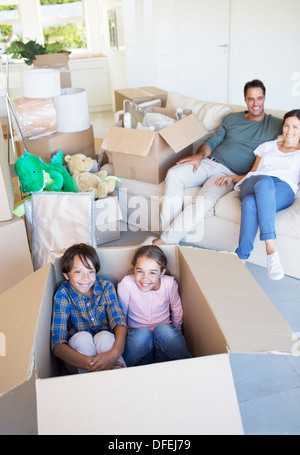 Bruder und Schwester in Karton im Wohnzimmer Stockfoto