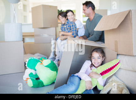Familie unter den Kartons im Wohnzimmer Stockfoto