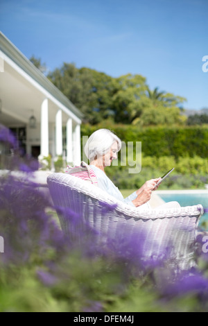 Ältere Frau mit digital-Tablette im Garten Stockfoto