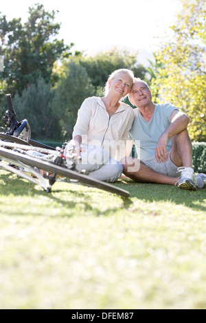 Älteres paar sitzen im Park mit dem Fahrrad Stockfoto