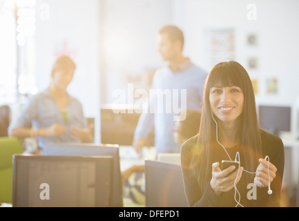Geschäftsfrau, anhören von MP3-Player im Büro Stockfoto