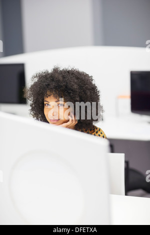 Geschäftsfrau, die lächelnd am Schreibtisch im Büro Stockfoto