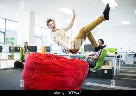 Geschäftsmann, Sprung ins Sitzsack im Büro Stockfoto