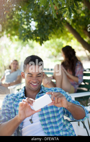 Mann mit Kamera-Handy im park Stockfoto