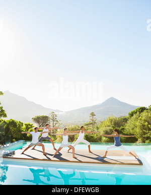 Menschen praktizieren Yoga am Pool Stockfoto