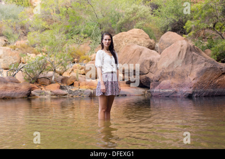 Porträt der Frau waten im Fluss Stockfoto