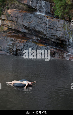 Frau im Innenrohr am Fluss schweben Stockfoto