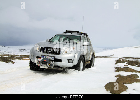 Stark modifizierte Toyota Landcruiser fahren auf Schnee in Island Stockfoto