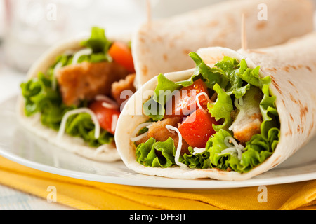 Panierte Chicken in einer Tortilla-Wrap mit Salat und Tomate Stockfoto