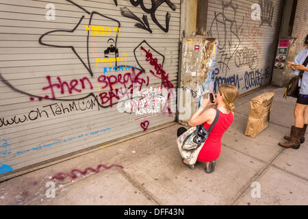 Zweite Tranche der Banksy-Graffiti-Kunst auf einer Rolle Tor im New Yorker Stadtteil Chelsea auf Donnerstag, 3. Oktober 2013, gemalt auf Mittwoch und bereits verwüstet. 'Das ist mein New York Akzent' Kunstwerk entstand durch die schwer fassbare Streetart-Künstler, die Werke in der Stadt, jeweils erstellen werden Tag, im Laufe des Monats Oktober. Die Schablonen sind begleitet von eine satirische aufgezeichnete Nachricht ein Museumsrundgang, die Sie hören können telefonisch unter der Nummer 1-800-656-4271 gefolgt von # und die Anzahl von Kunstwerken zu parodieren.  (© Richard B. Levine) Stockfoto