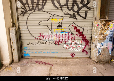 Zweite Tranche der Banksy-Graffiti-Kunst auf einer Rolle Tor im New Yorker Stadtteil Chelsea auf Donnerstag, 3. Oktober 2013, gemalt auf Mittwoch und bereits verwüstet. 'Das ist mein New York Akzent' Kunstwerk entstand durch die schwer fassbare Streetart-Künstler, die Werke in der Stadt, jeweils erstellen werden Tag, im Laufe des Monats Oktober. Die Schablonen sind begleitet von eine satirische aufgezeichnete Nachricht ein Museumsrundgang, die Sie hören können telefonisch unter der Nummer 1-800-656-4271 gefolgt von # und die Anzahl von Kunstwerken zu parodieren.  (© Richard B. Levine) Stockfoto