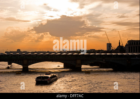 Ein Boot auf der Themse verläuft unter der Blackfriars Bridge in London. Die Brücke hat 4.400 Sonnenkollektoren auf dem Dach Cr installiert. Stockfoto