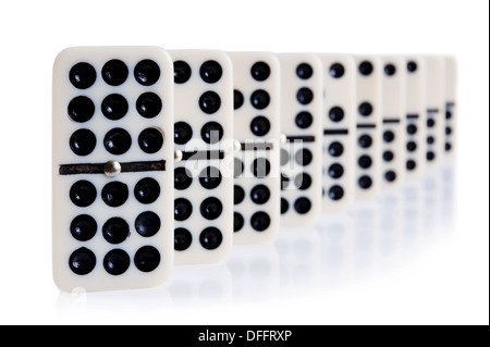Domino in Reihe auf weiß mit Lichtreflexion auf dem Hintergrund Stockfoto