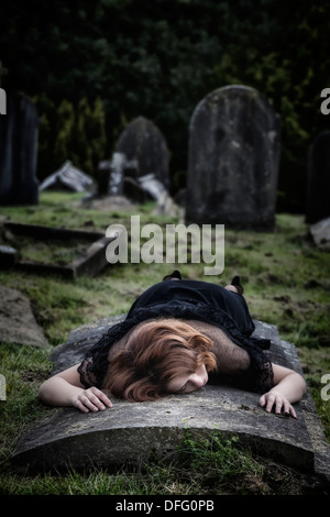 eine Frau liegt auf einem Grab Stockfoto