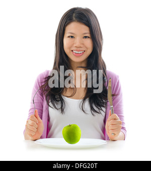 Gesund essen-Konzept. Asiatische Mädchen hält bereit, grünen Apfel auf Teller zu essen. Isoliert auf weißem Hintergrund. Stockfoto