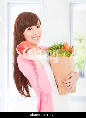 schöne junge Frau mit Apfel und Gemüse Stockfoto
