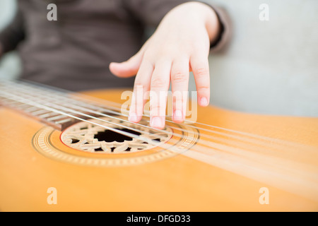 Junges Mädchen, 4 Jahre alt, auf einer akustischen Gitarre zu spielen. Stockfoto