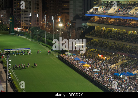 Start eines Rennens bei einem Nachtrennen in Happy Valley Racecourse, Hong Kong, China Stockfoto