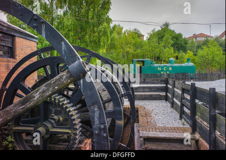 Eine Nachbildung eines kleinen Bergbau Grube Kopf gewundenen Gang im Vordergrund und eine alte N.C.B. Rangier-Lok im Hintergrund Stockfoto