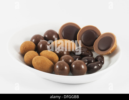 Schokoladenbonbons auf einem weißen Teller. Isoliert. Stockfoto