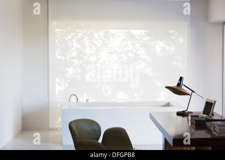 Schreibtisch und Badewanne im modernen Haus Stockfoto