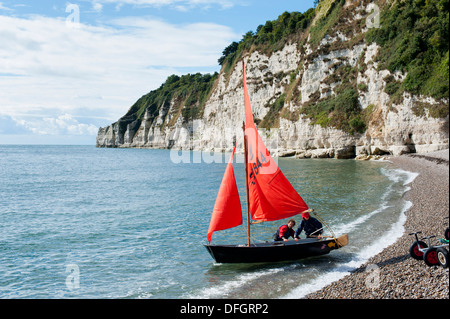 Segelboot mit roten Segel an Bier Devon England Stockfoto