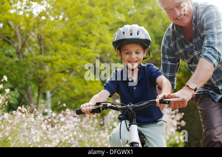 Großvater lehrt Enkel, Fahrrad fahren Stockfoto