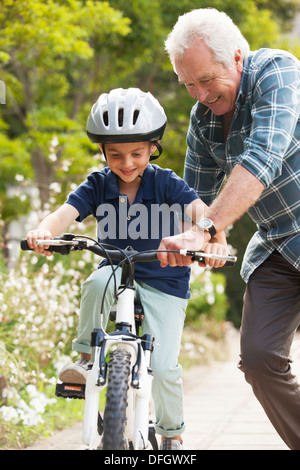 Großvater lehrt Enkel, Fahrrad fahren Stockfoto